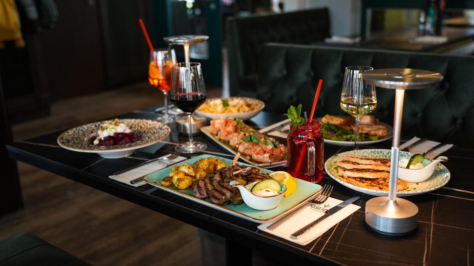 Reich gedeckter Tisch mit griechischen Gerichten und Drinks