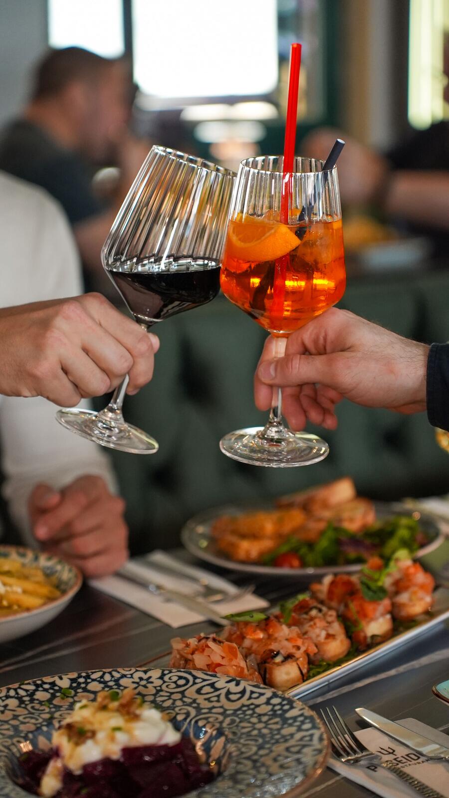 Gäste stoßen mit Wein und Aperitif an